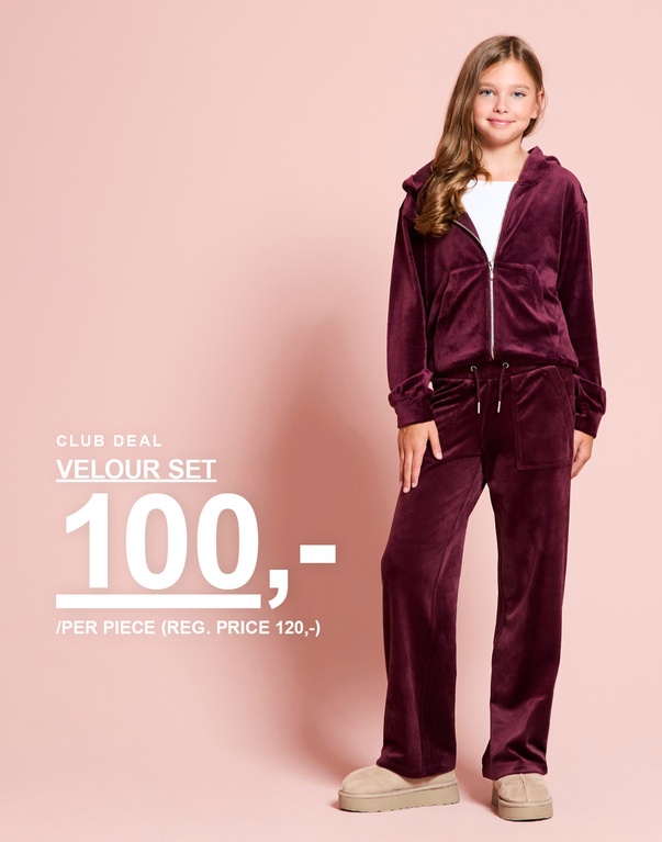 En jente har på seg et burgunder veloursett med hettejakke og bukse. CLUB DEAL – VELOUR SET 100:- / PER PIECE (REG. PRICE 120:-).