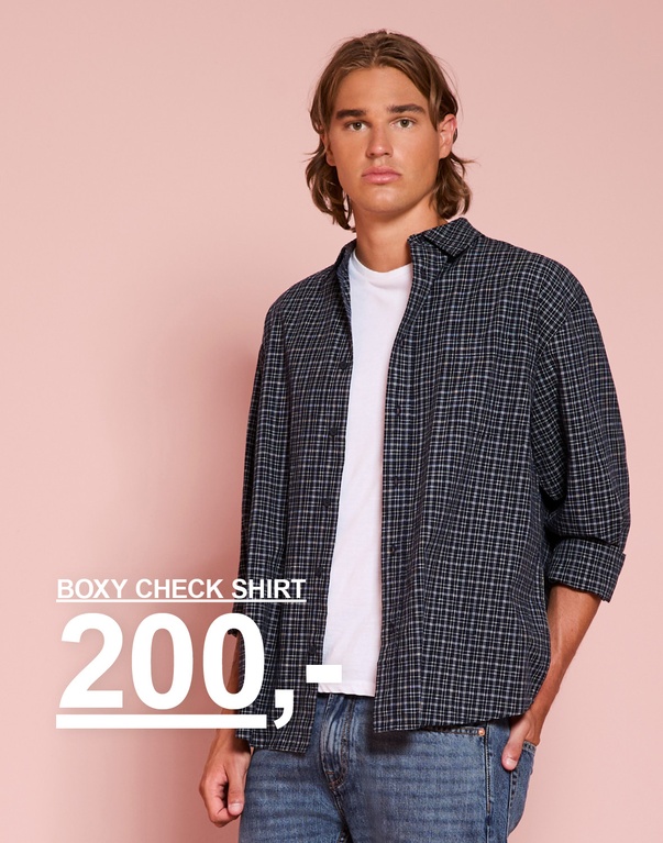 Gutt i rutete skjorte, hvit t-skjorte og jeans. Kampanjetekst: "BOXY CHECK SHIRT 200,-"