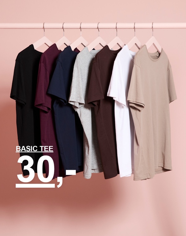 T-skjorter i flere farger på hengere. Kampanjetekst: “BASIC TEE 30,-”.