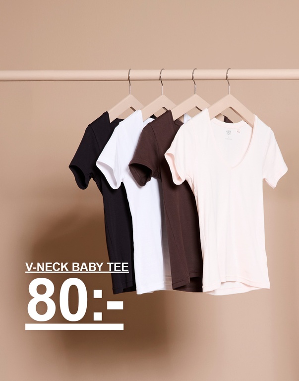 V-ringade baby tees på galge i färgerna svart, vit, brun och offwhite. Kampanjtext: "V-NECK BABY TEE, 80:-".