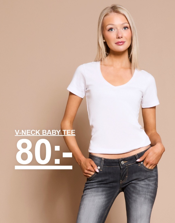 Tjej i vit v-ringad baby tee och mörka jeans. Kampanjtext: "V-NECK BABY TEE, 80:-".