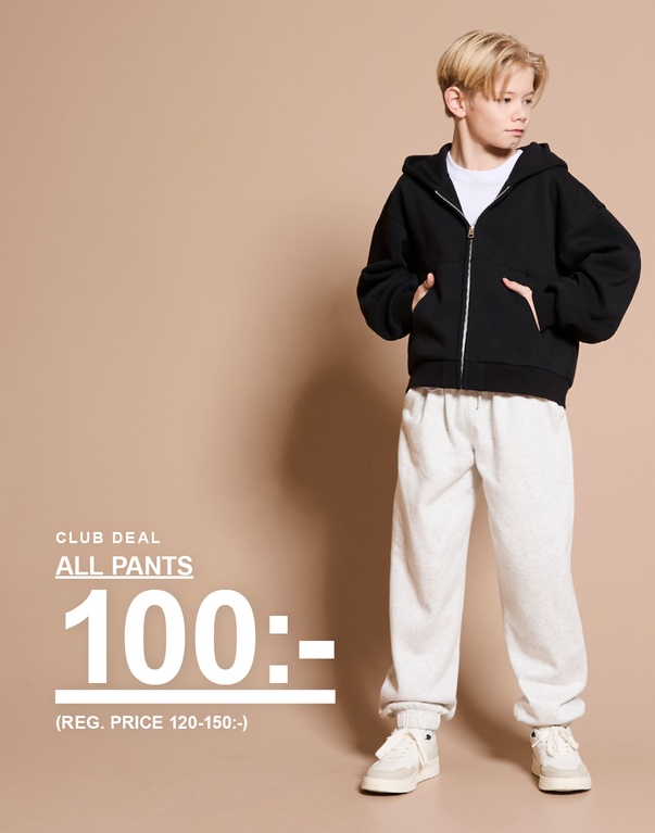 Barn i svart hoodie och ljusa byxor står mot ljus bakgrund. Text: ”Club deal”, ”All pants 100:- (reg. price 120–150:-)”.