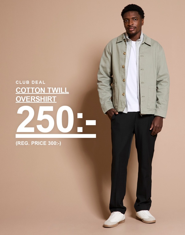 Man i ljus cotton twill overshirt med vit t-shirt och svarta byxor mot beige bakgrund. Kampanjtext: “CLUB DEAL COTTON TWILL OVERSHIRT 250:- (REG. PRICE 300:-)”.