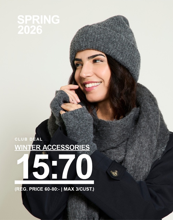 Kvinna i grå stickad mössa och grå halsduk, klädd i svart jacka mot ljus bakgrund. Club deal winter accessories 15:70 (reg. price 60–80:- | max 3/cust.)