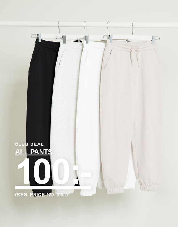 Byxor i svart, grått, vitt och beige hänger på galgar mot ljus bakgrund. Kampanjtext: ”Club deal All pants 100:- (reg. price 120–150:-)”.