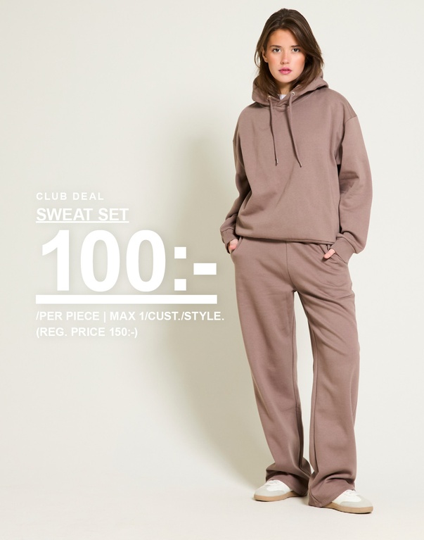 Tjej i brunt sweat set. Kampanjtext: 'CLUB DEAL, SWEAT SET, 100:- (ORD. PRIS 150:-)'. Max 1/kund/style