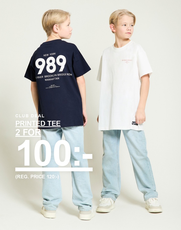 Två pojkar i tryckta t-shirts i marinblått och vitt med ljusblå jeans mot ljus bakgrund. CLUB DEAL PRINTED TEE 2 FOR 100:- (REG. PRICE 120:-)