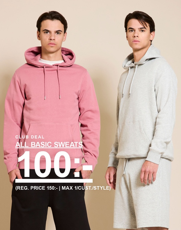 Två män i hoodies och sweatshorts – rosa hoodie med svarta shorts och grå hoodie med matchande shorts framför beige bakgrund. CLUB DEAL. ALL BASIC SWEATS 100:- (REG. PRICE 150:- | MAX 1/CUST./STYLE)
