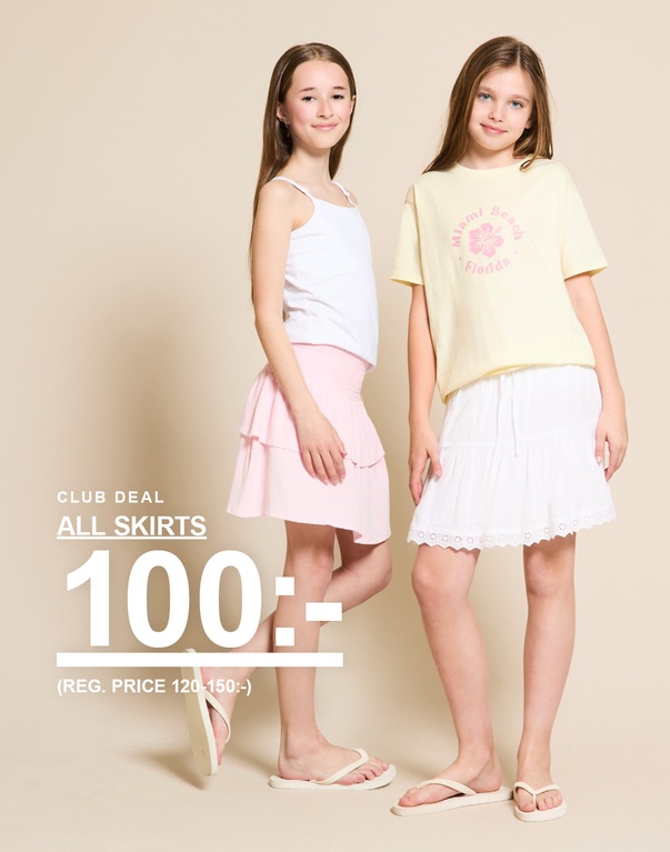 Två barn i kjolar och toppar i färgerna rosa, gul och vit framför en ljus bakgrund. CLUB DEAL ALL SKIRTS 100:- (REG. PRICE 120-150:-)