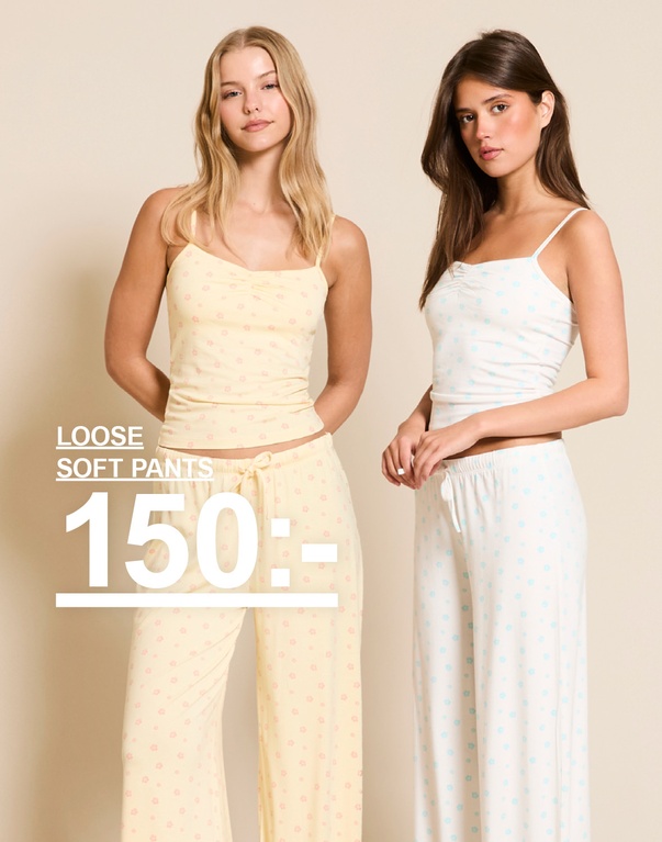 Två tjejer i loose soft pants med blommigt mönster, ett set i ljusgul och ett set i vit med ljusblå blommor. Kampanjtext: "LOOSE SOFT PANTS, 150:-".