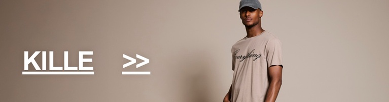 Kille i beige T-shirt med tryck och ljusa jeans. Kategori-knapp med texten "KILLE >>".