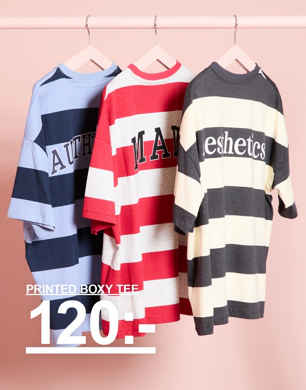 Tre randiga printed boxy t-shirts på galgar i ljusblått/mörkblått, rött/vitt och mörkgrått/offwhite. Kampanjtext: "PRINTED BOXY TEE 120:-"