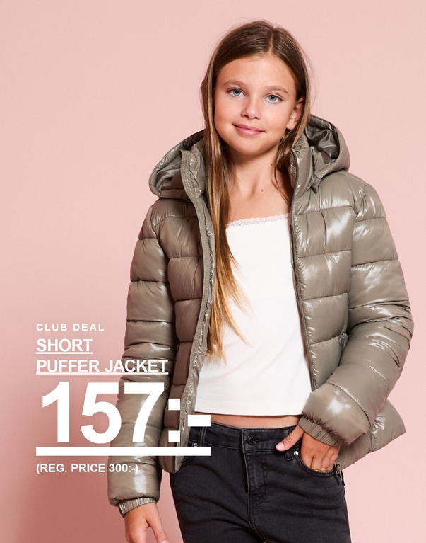Ett barn bär en grön pufferjacka. Club deal: Short puffer jacket 157:- reg.price 300:-