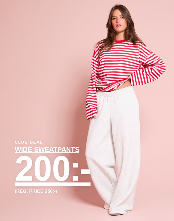 Tjej i röd- och vitrandig långärmad tröja och ljusgrå sweatpants. Kampanjtext: "CLUB DEAL – WIDE SWEATPANTS 200:- (ORD. PRIS 250:-)"