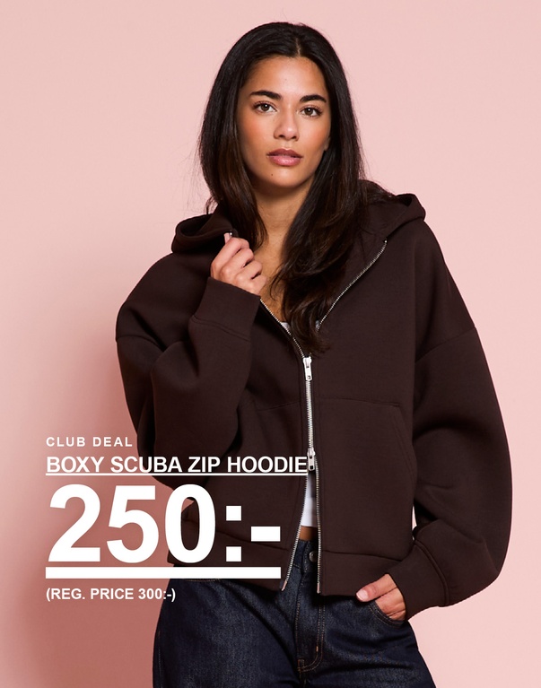 Tjej i brun boxy scuba zip hoodie. Kampanjtext: “BOXY SCUBA ZIP HOODIE, 250:- (ORD. PRIS 300:-)”.