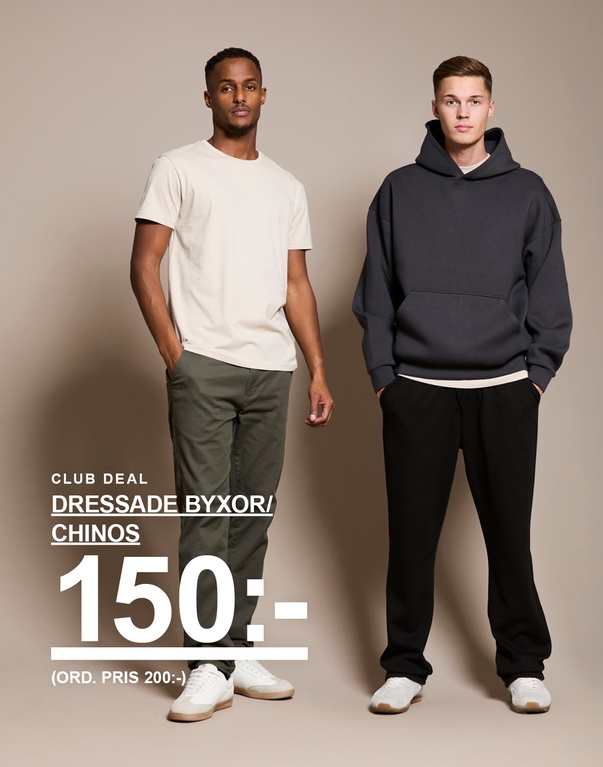 Två män, en i beige t-shirt och gröna chinos, den andra i mörkgrå hoodie och svarta byxor. Text: “Dressade byxor/chinos 150 kr (ord. pris 200 kr)”.