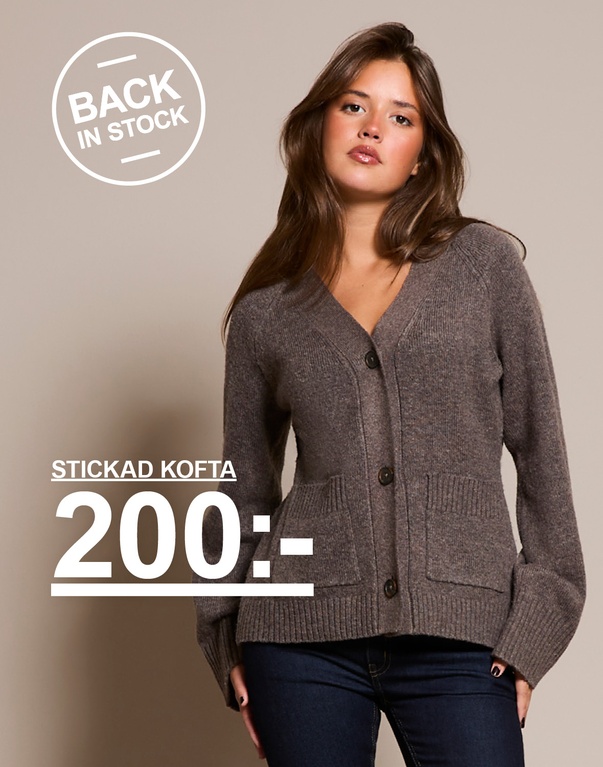 Tjej i Brun stickad kofta med knappar och fickor framtill. Kampanjtext: 'BACK IN STOCK, STICKAD KOFTA, 200:-'