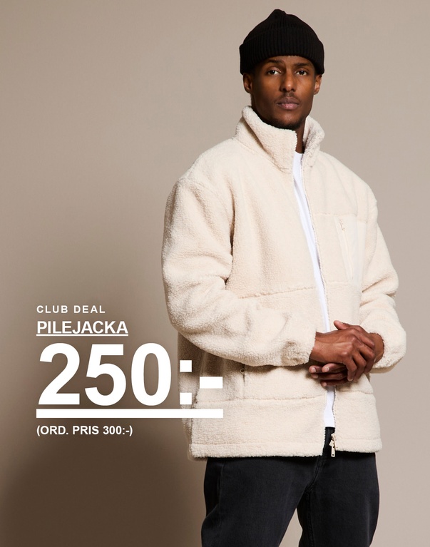 Man bär en beige pilejacka med dragkedja, svart mössa och vit t-shirt. Text på bilden visar erbjudande: “Pilejacka 250 kr (ord. pris 300 kr)”.