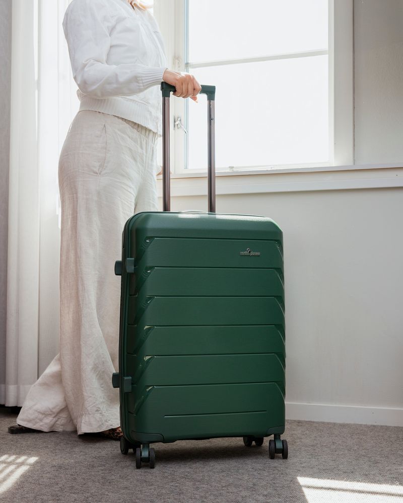 grön stor resväska på ett hotellrum, modellen London från North Pioneer