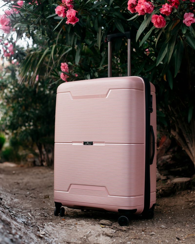 liten rosa resväska med hjul och teleskophandtag