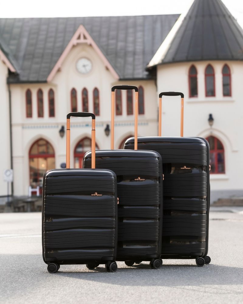 svarta resväskor kabin, medium och stor från North Pioneer utanför tågstation