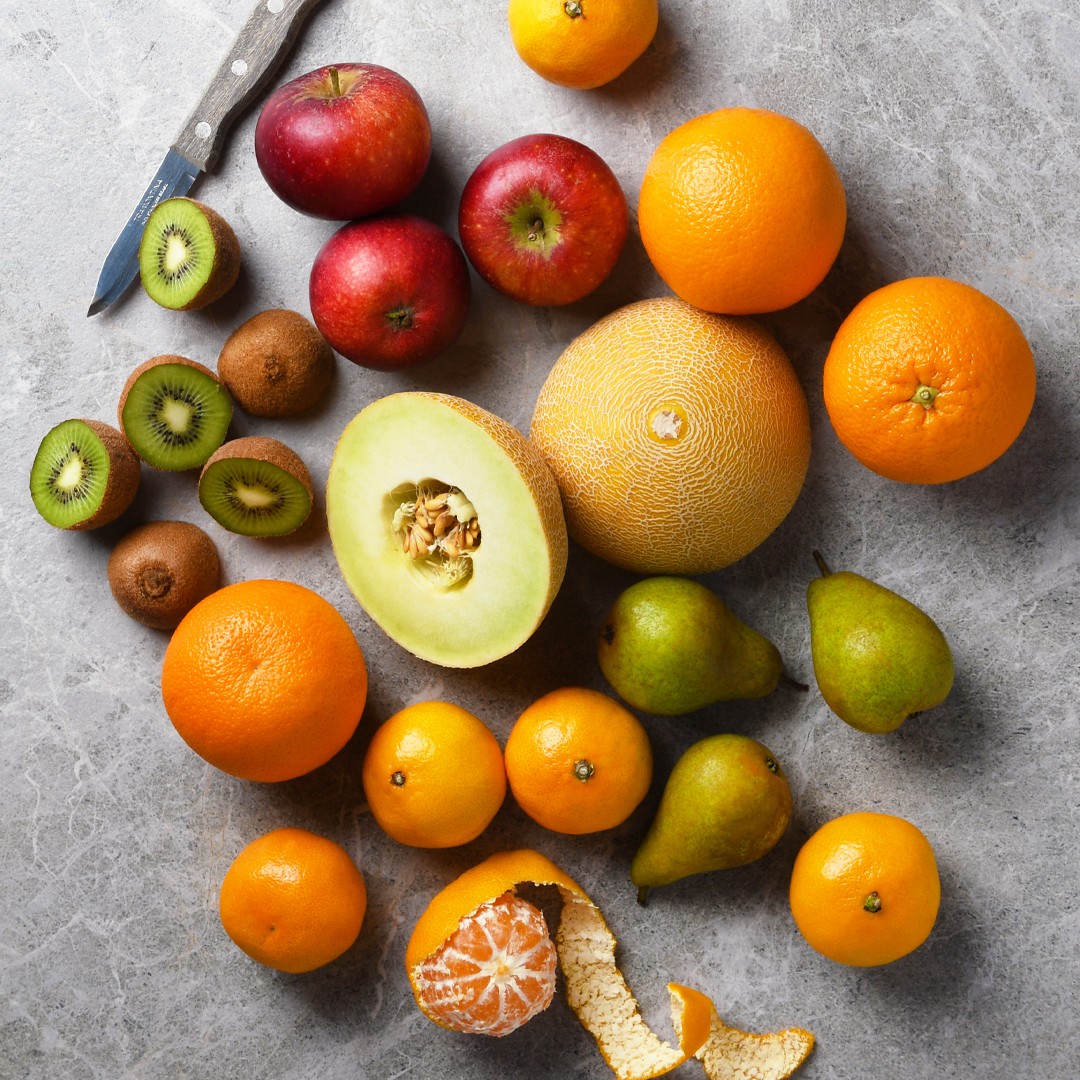 Fruktkasse med apelsiner, blåbär, melon och päron