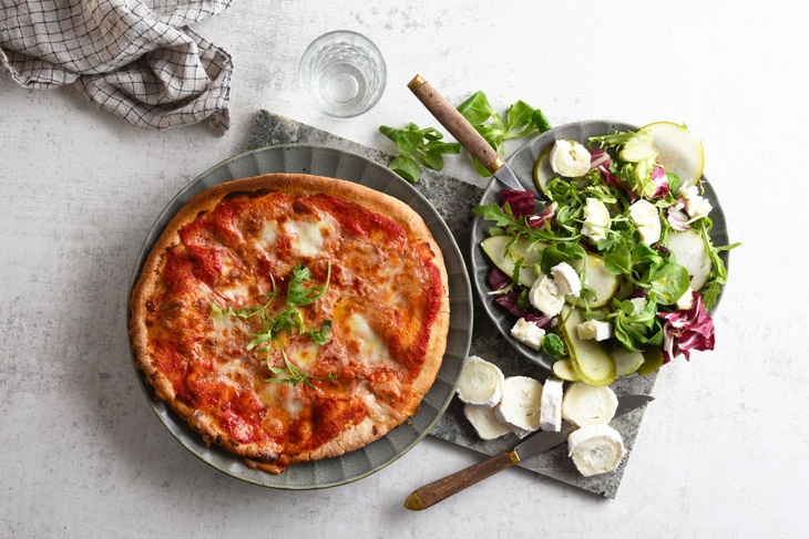 Pizza margarita med en sallad på getost och päron