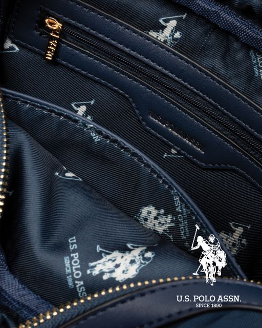 Innside av mørkeblå veske med mønstret fôr og glidelåslommer fra U.S. Polo Assn.