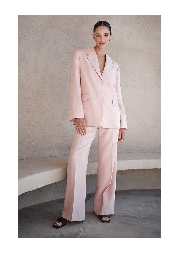 Tyttö, jolla on päällään vaaleanpunainen puku merkiltä Stockholm Studio.