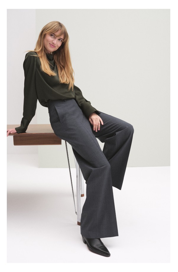 Harmaat naisten housut, joissa on laskokset.