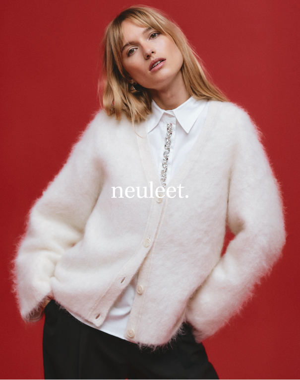 Valkoinen paita kivillä ja valkoinen neuletakki naisille