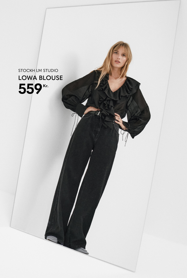 Feminim sort bluse med dyb v udskæring og flæser.