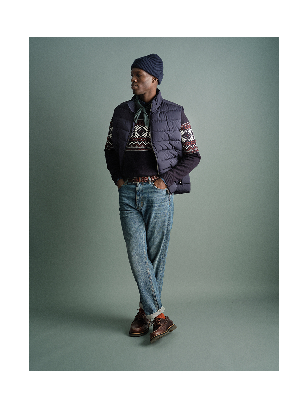 Joulukampanja brändiltä Bondelid. Mies seisoo ja on pukeutunut neulepuseroon ja untuvatakkiin. Hänellä on pipo päässä.