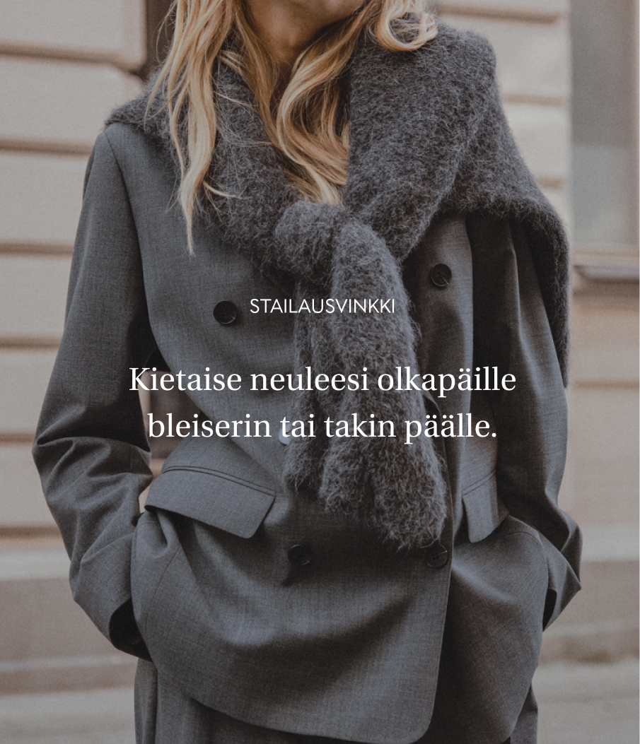 Harmaa bleiseri naisille, harmaa neulepusero olkapäillä.