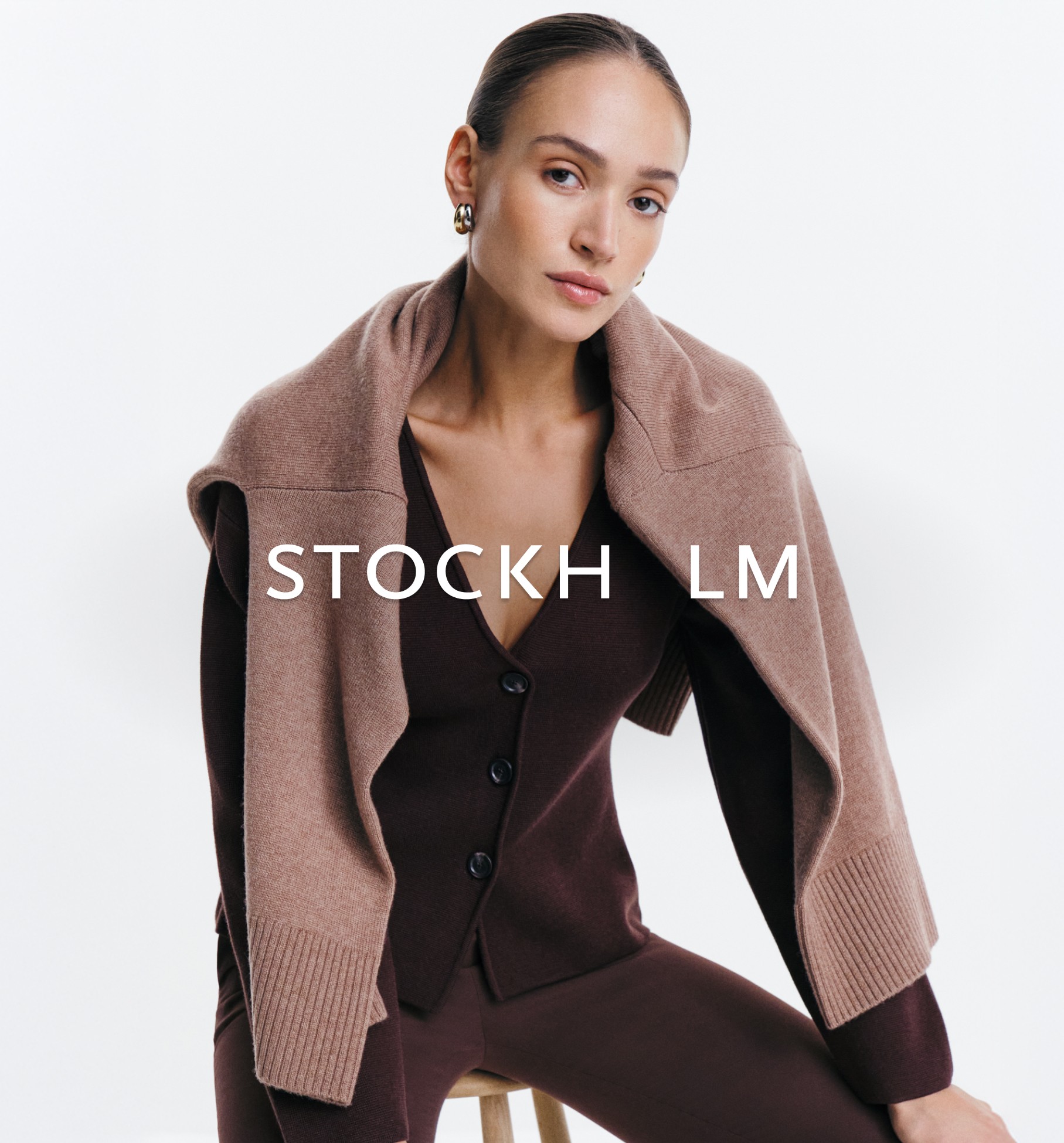 Nainen Stockh lmin vaatteissa. Tummansininen röyhelöinen paita.