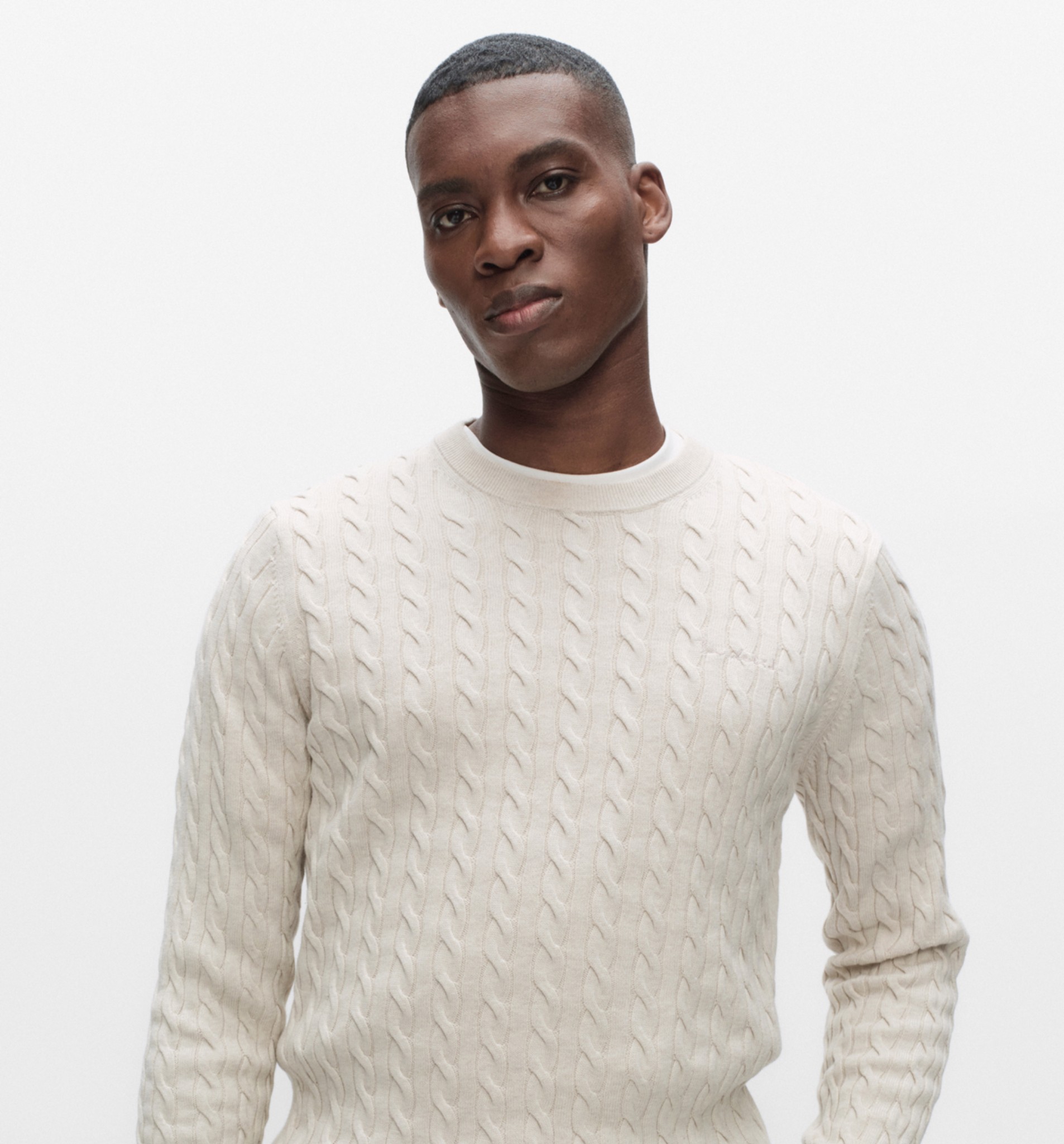 Valkoinen miesten neulepusero, pyöreä kaulus ja palmikkokuvio