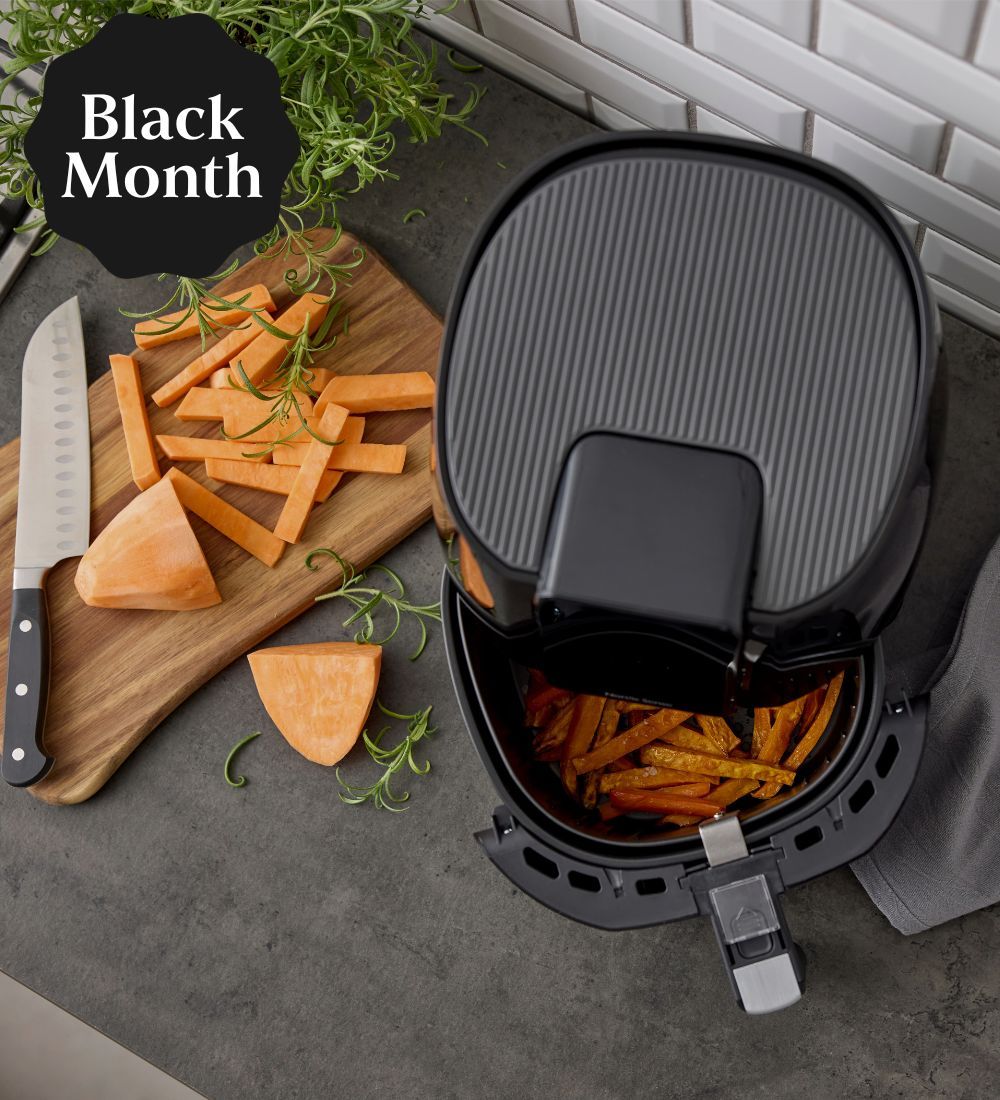 En svart airfryer med sötpotatispomme inuti
