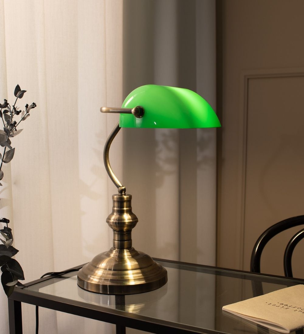 En grön bordslampa i gulddetaljer