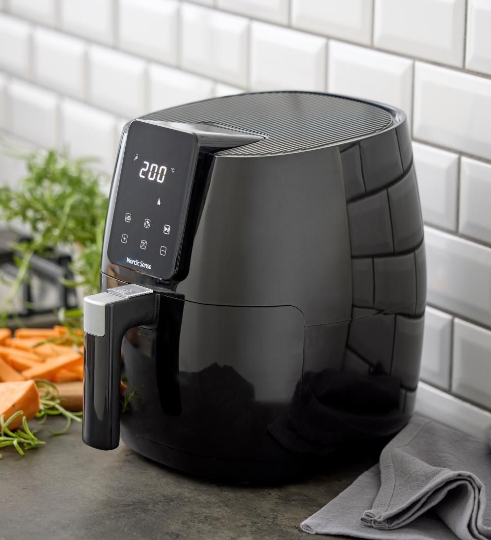 En svart airfryer ståendes på en köksbänk