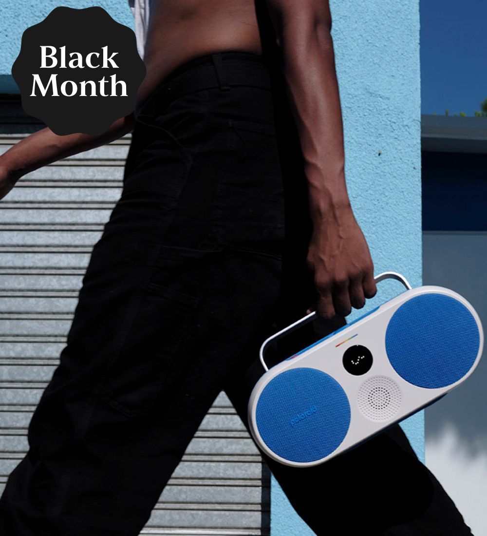 En människa som håller i en vit och blå högtalare från Polaroid