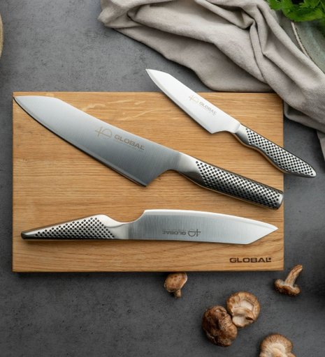Tre rostfria knivar från Global på en skärbräda av trä