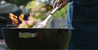 Eld rykandes från en svart grill 