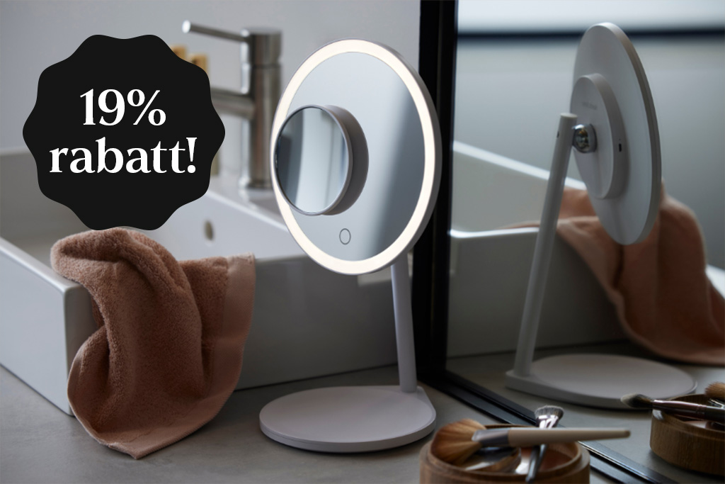 En vit make-up spegel i ett grått badrum