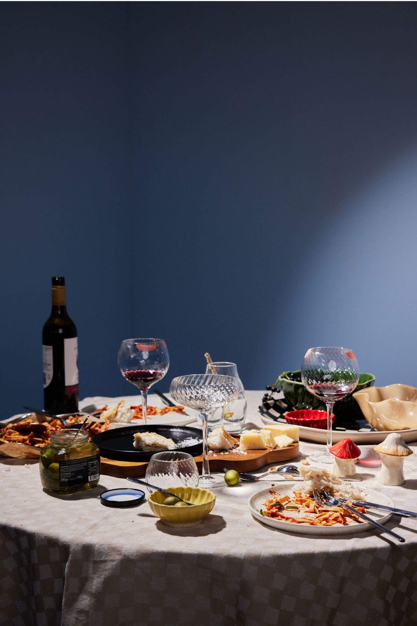 Ett runt matbord dukat för middag med vinglas och tallrikar