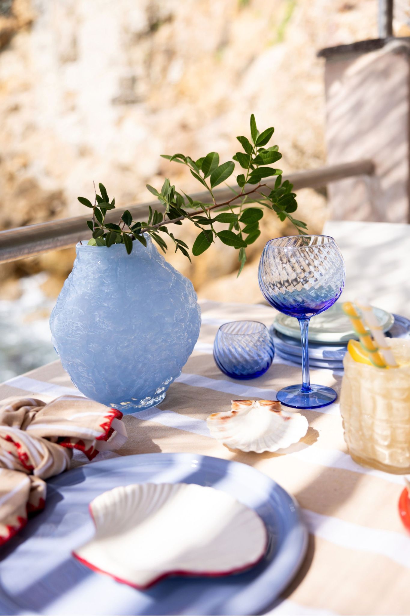 Ett dukat bord i solen med blått porslin