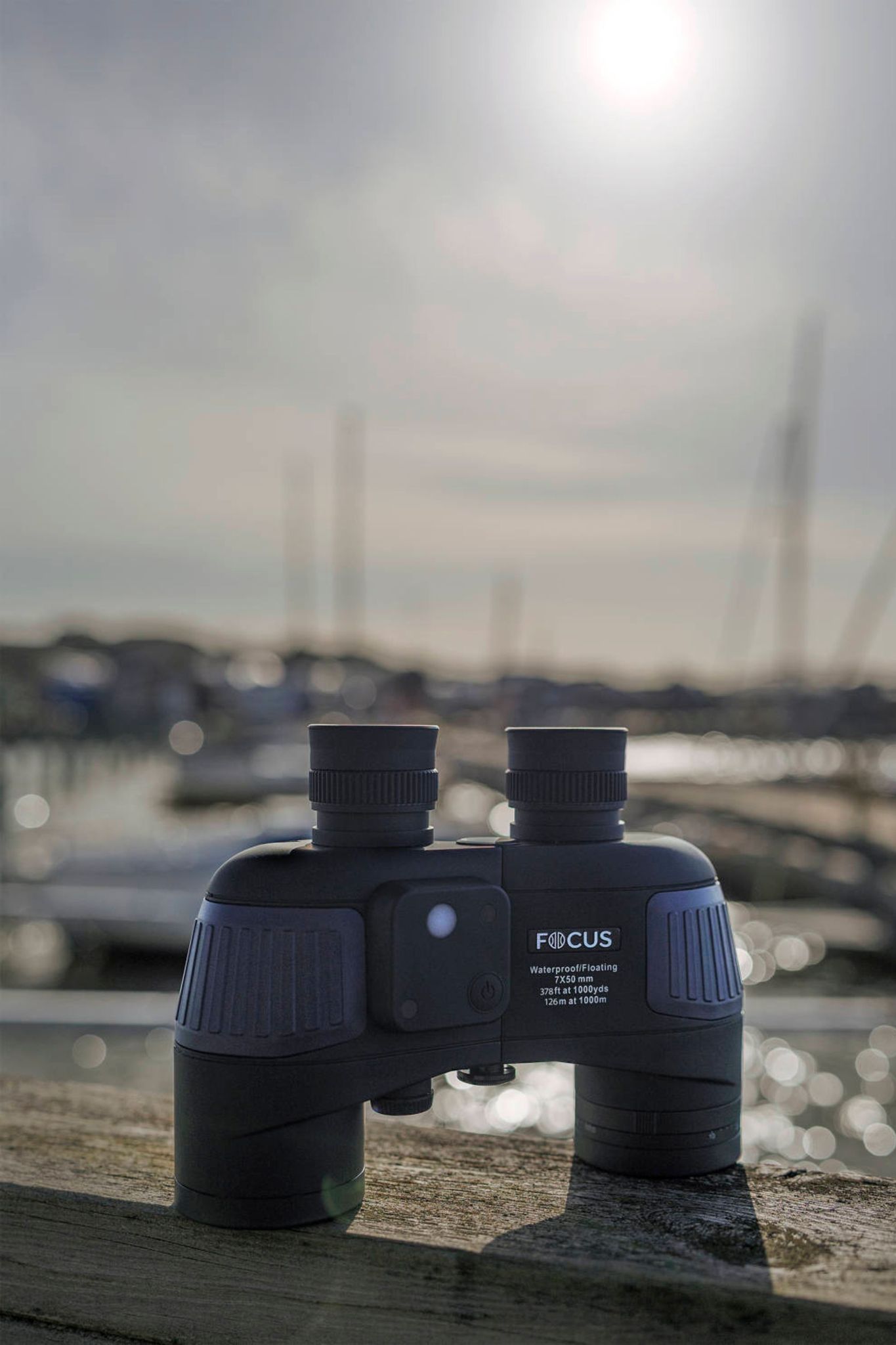 En svart kikare på en brygga