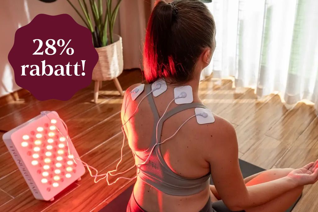 En person sittandes på en matta med en rödljuslampa bredvid sig