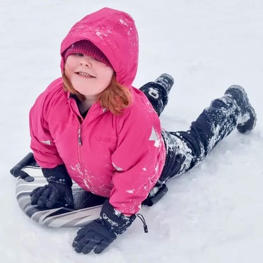 Gneis Speed Space vinterjacka i cerice. Varm, vattentät och smidig. Barn ligger på mage i snön.