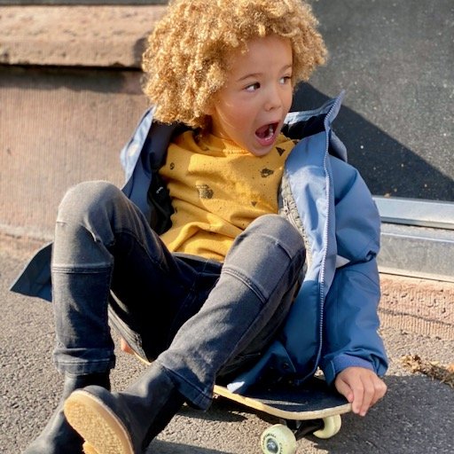 Ett barn som har på sig Ossoami slitstarka jeans och Speed jacka från Gneis