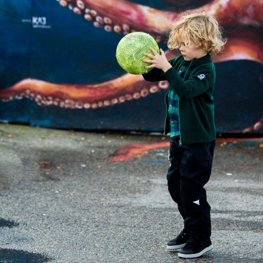 Barn leker med boll i Dolomit Shell skalbyxa och Ulle ulltröja från Gneis